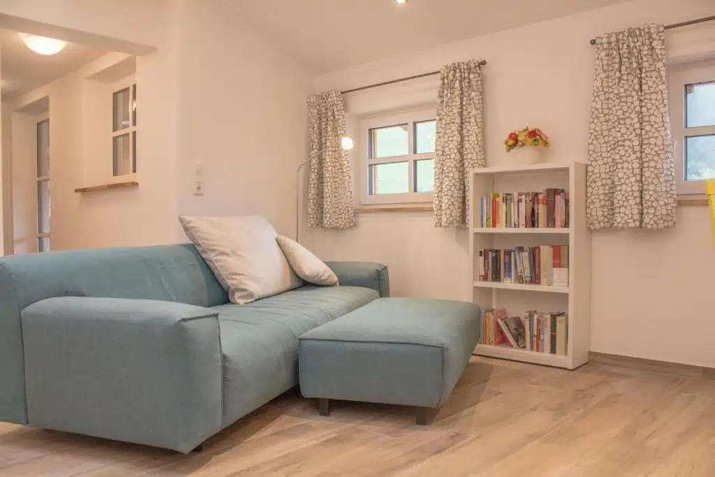 Unsere Apartments 8 Gezellige woonkamer met bank en boeken